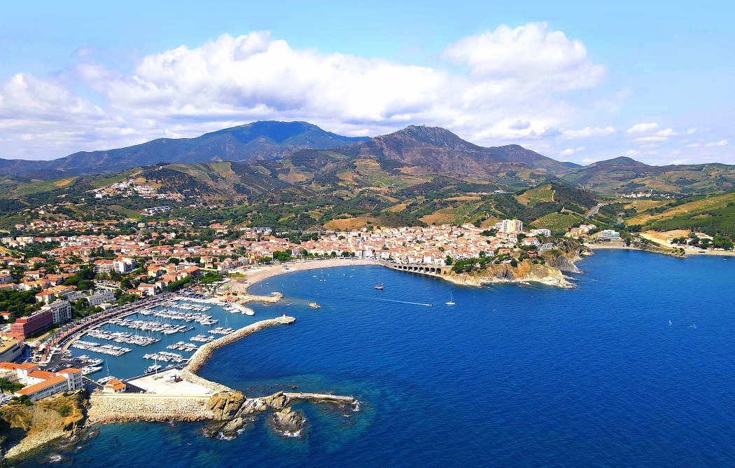 stock-photo-aerial-view-of-the-city-of-banyuls-sur-mer-between-mediterranean-sea-and-massif-des-alb-res-on-2019273026_2-1